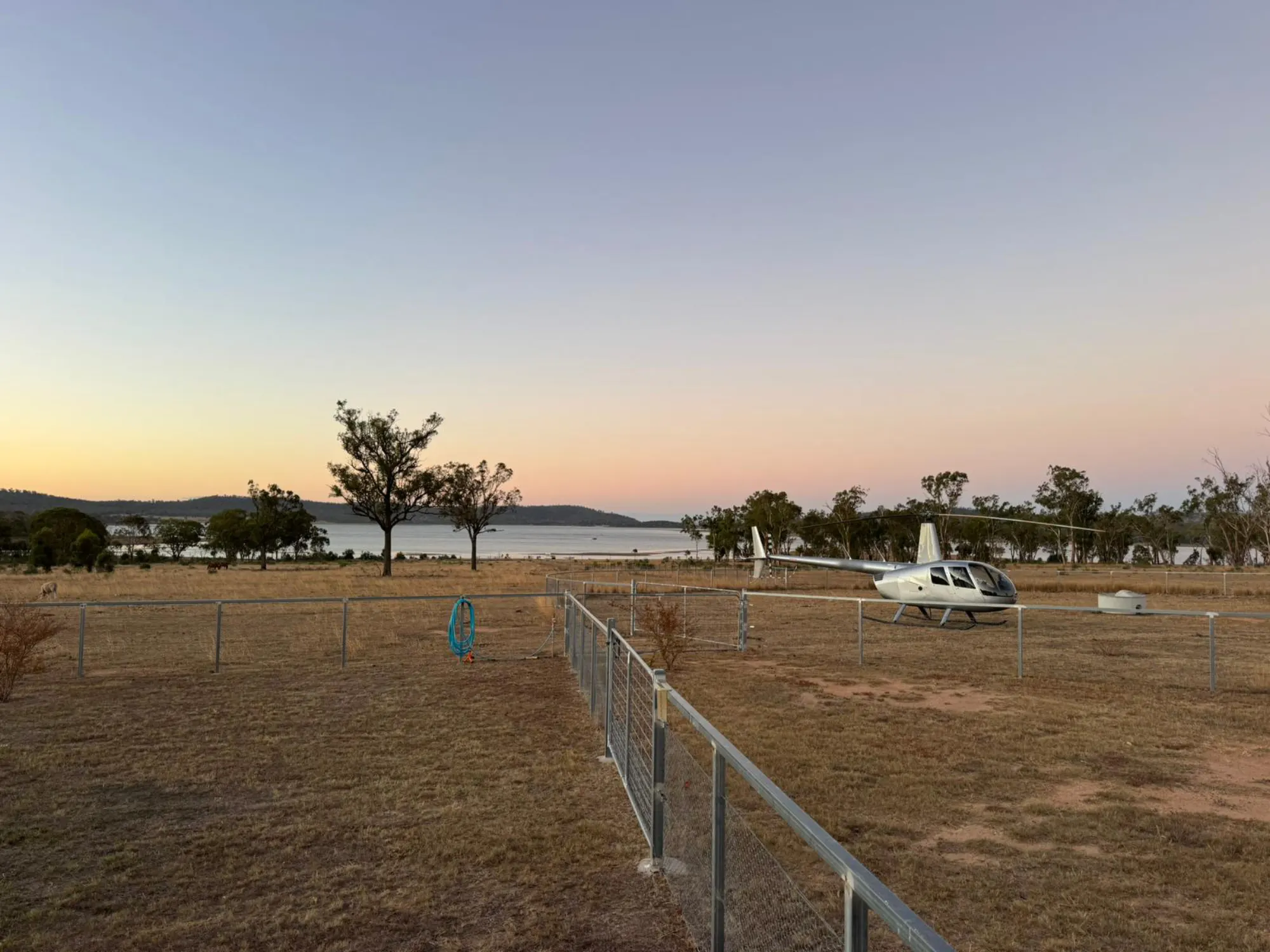 Helicopter parked at dusk, lake in the background