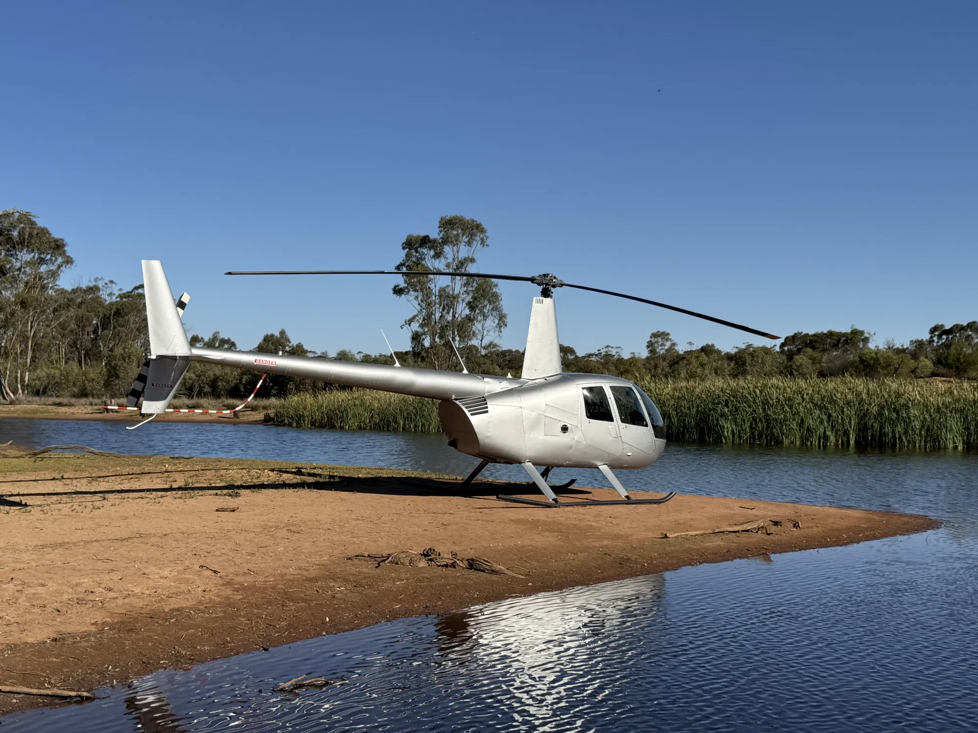 Helicopter parked on a river sandbar