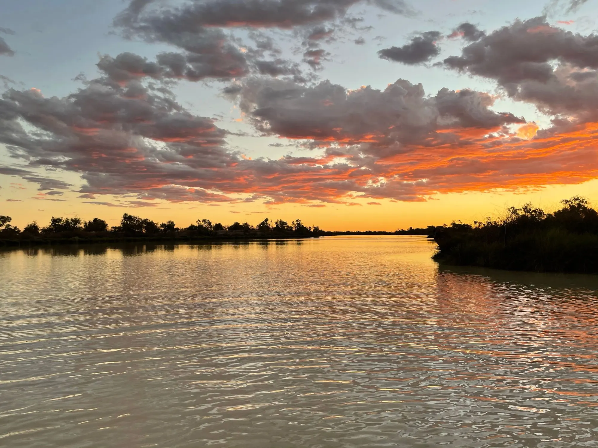 Country river under a fiery orange sunset