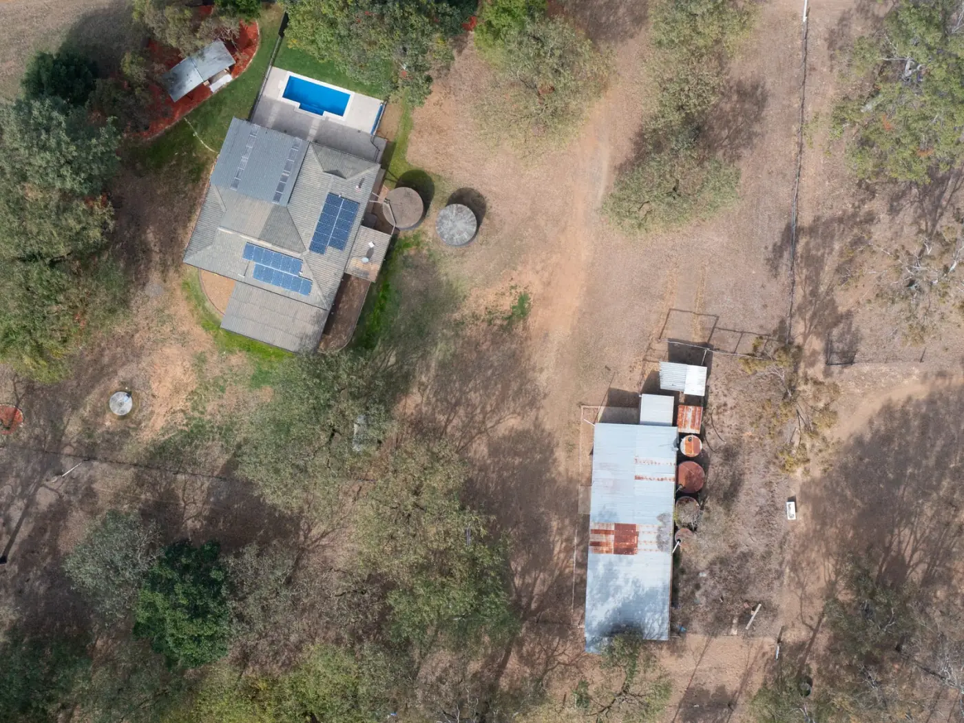 Aerial view of the 4.94 acre property showing the home, pool and shed