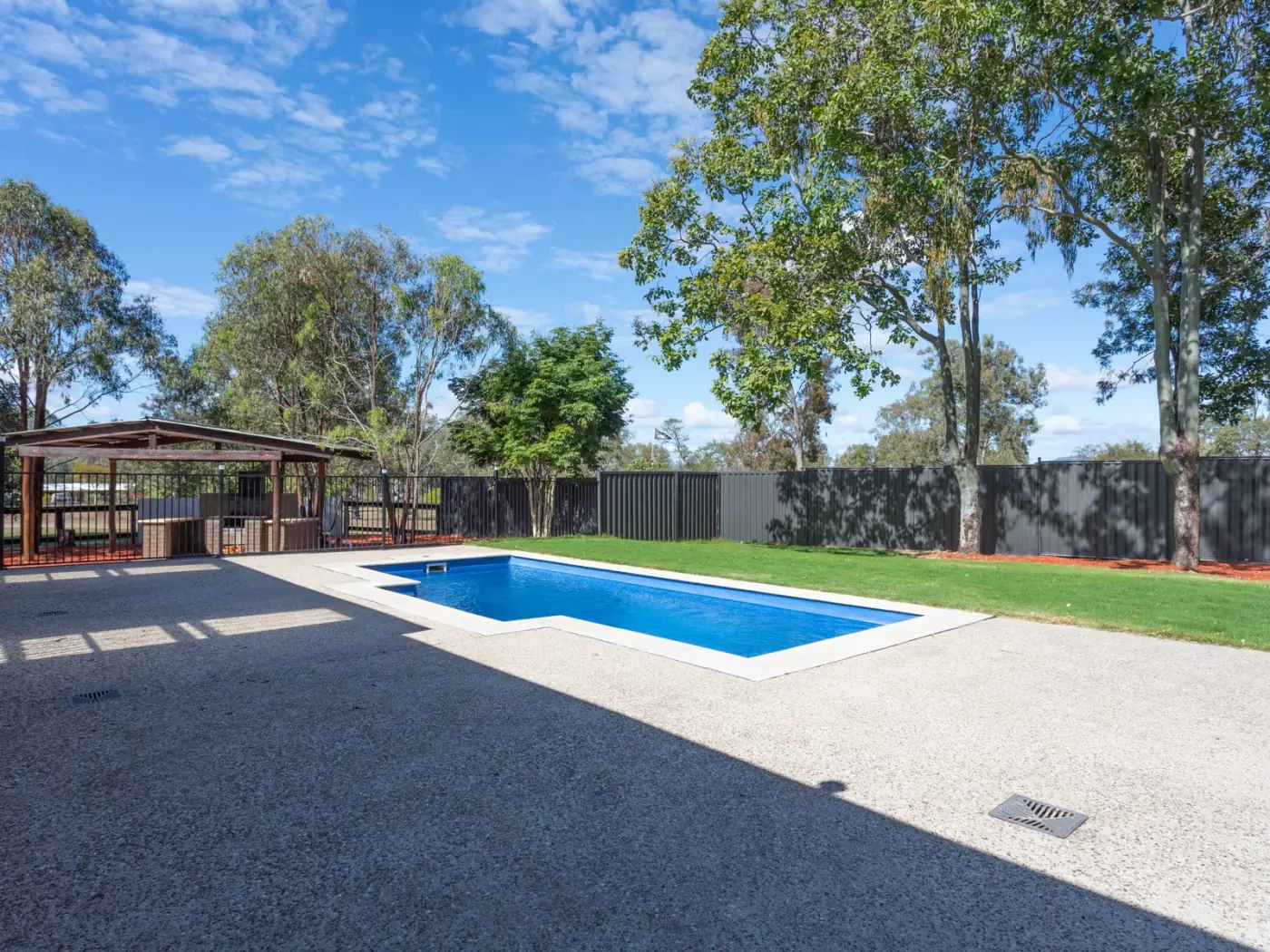 In-ground pool with the shed and paddocks beyond