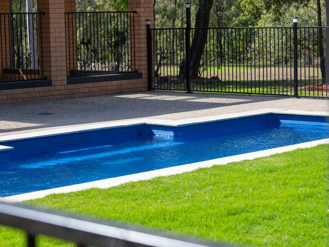 Fenced in-ground swimming pool beside the lawn